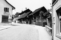 1955  Neue Dorfstrasse, anstelle der Scheunen steht heute die Drogerie Wehrli